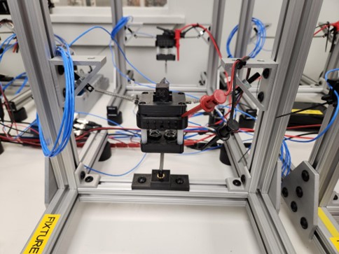 A vibration test setup for a haptic motor. The setup includes an apparatus that holds the motor. The apparatus is suspended by springs.